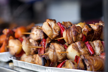 Close up of traditionally grilled pork and beef meat on a wooden stick. Eastern European traditional shish kebab with grilled vegetables.  
