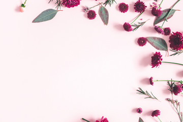 Flowers composition. Eucalyptus leaves and pink flowers on pastel pink background. Flat lay, top view, copy space