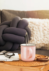 Tea in the cup standing on the small wooden table in the living room
