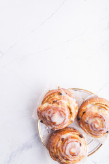 Cinnamon rolls buns on a white marble wooden background. Bakery concept. Breakfast and brunch. Flatlay. Minimalistic photo. Overhead. Copy space