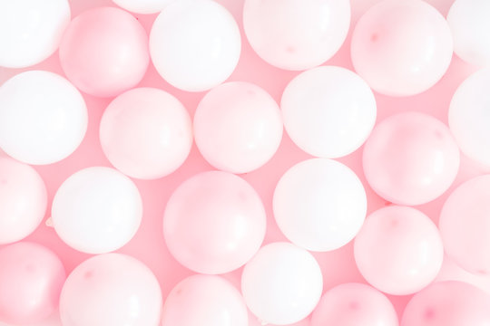 Balloons on pastel pink background. Pattern made of white and pink balloons. Birthday, valentines day, holiday concept. Flat lay, top view, copy space