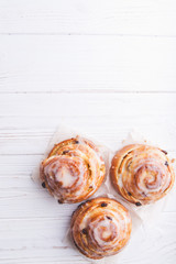 Fototapeta premium Cinnamon rolls buns on a white marble wooden background. Bakery concept. Breakfast and brunch. Flatlay. Minimalistic photo. Overhead. Copy space
