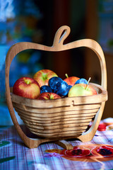 Basket and fresh fruits on wooden table