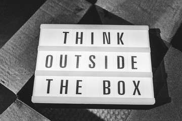 Think outside the box message on lightbox on top of open parcel
