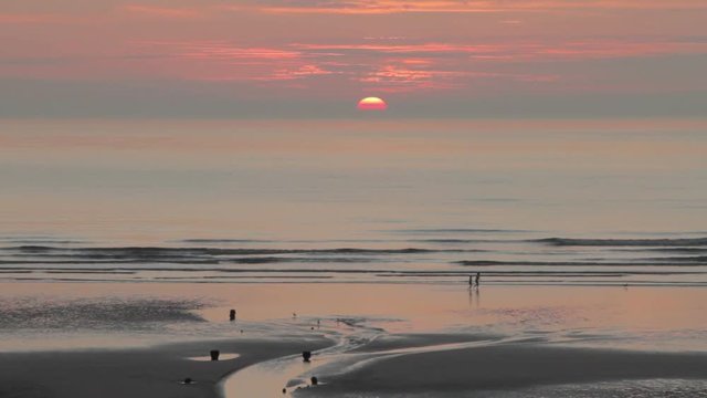 Two people on Blackpool beach at sunset