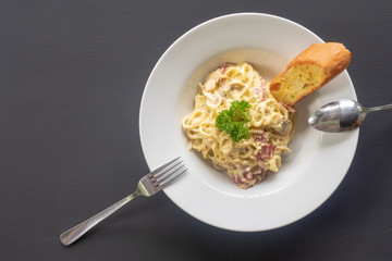 Carbonara paste on a white plate on a dark background