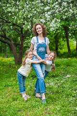 Fototapeta premium Family walks in blooming apple orchard in spring