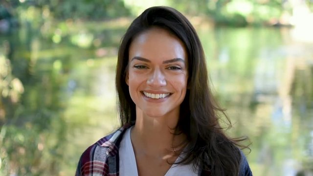 Beautiful atractive girl with big stunning smile in front of lake