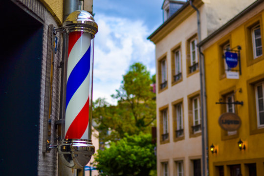 The famous and classic symbol of a barber shop. Close up of rotating red, white and blue barber shop light in Luxembourg, Europe