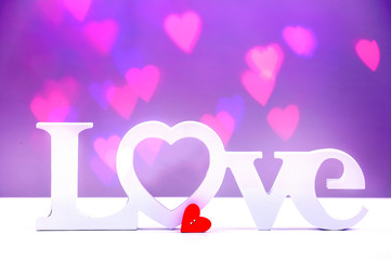 Love word on blurred hearts background.Valentine's day background.
