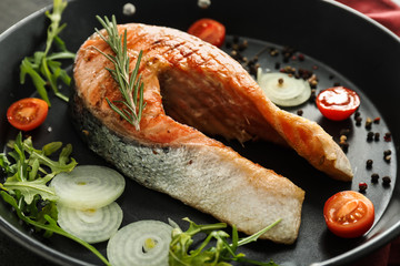 Tasty grilled salmon steak with spices in frying pan