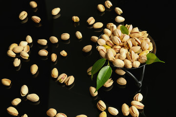 Stand with tasty pistachio nuts on dark background