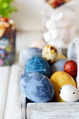 Colored Easter eggs in a wooden basket on a white background. Happy easter. Easter decoration.