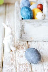 Colored Easter eggs in a wooden basket on a white background. Happy easter. Easter decoration.