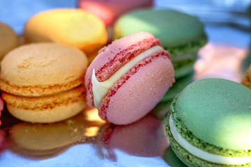 French cake macaron or macaroon at picnic outdoors. Colorful cookies made from almond flour in pastel colors. 