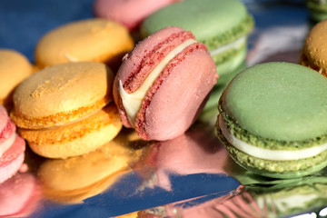 French cake macaron or macaroon at picnic outdoors. Colorful cookies made from almond flour in pastel colors. 