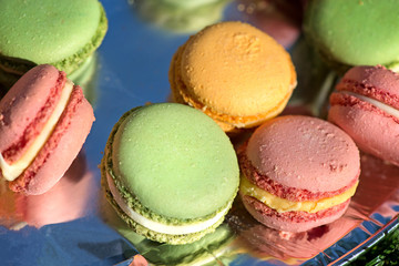 French cake macaron or macaroon at picnic outdoors. Colorful cookies made from almond flour in pastel colors. 