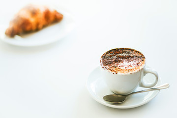 Cappuccino coffee and croissant isolated on white background
