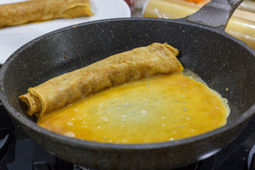 The process of cooking Japanese omelet roll. Frying an omelet in a pan