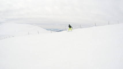 A girl rides a snowboard in the mountains. Lots of snow. Carpathians. Ski jacket and trousers.
