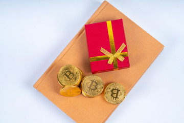 Book, red box gift and crypto coins with financial concept
