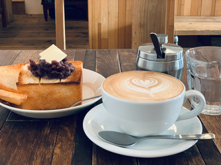 Coffee latte and toast bread with butter and japanese red bean at cafe.