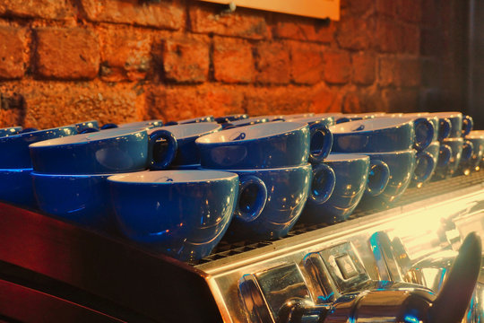 Blue cups of coffee on a coffee machine