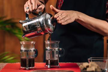 French Press Coffee. Barista Pouring French Press Coffee