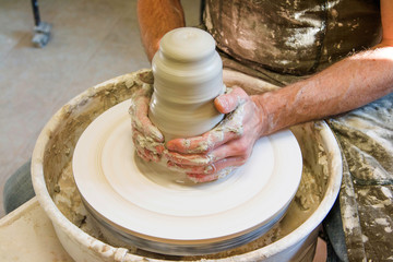      Manual worker in the workshop sculpting ceramic vase. Hands closeup detail. Small artistic craftsmen business concept. 