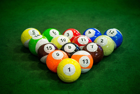 Shot of foot pool balls standing on green table. Foot Pool is the hybrid combination of pool and soccer. Big billiard balls. 