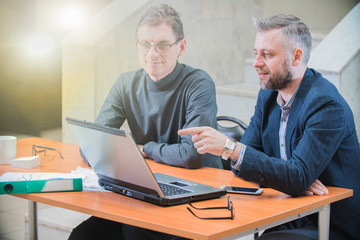 two colleagues sitting in the office at the laptop