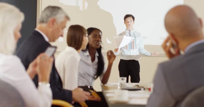 4K Fed up businessman trying to give a presentation with bored colleagues ignoring him. Slow motion.
