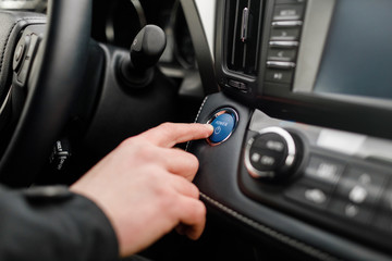 Naklejka premium Car driver starting the engine Start, stop engine button.