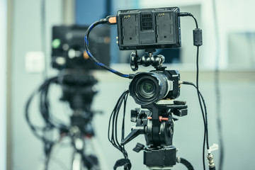 Professional film camera on a tripod in broadcasting studio
