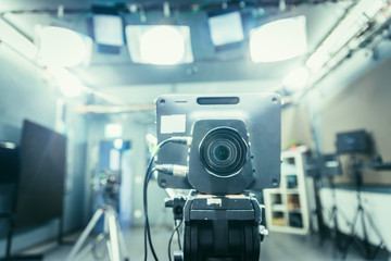 Film camera in broadcasting studio, spotlights and other equipment