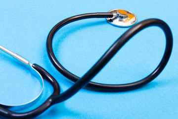 Health examination concept. Stethoscope on blue background close-up.