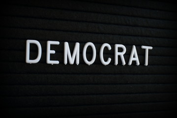 The word Democrat in white plastic letters on a black letter board