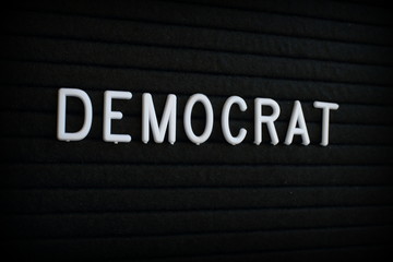 The word Democrat in white plastic letters on a black letter board