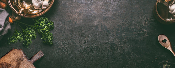 Abstracte voedselachtergrond. Bovenaanzicht van donkere rustieke keukentafel met houten snijplank en kooklepel, frame. Banner of sjabloon met kopieerruimte voor uw ontwerp. Keukengerei objecten