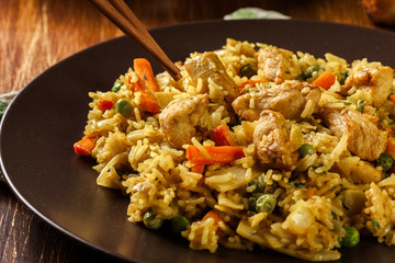 Fried rice nasi goreng with chicken and vegetables on a plate