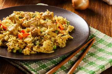 Fried rice nasi goreng with chicken and vegetables on a plate