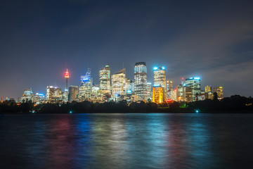 sydney cbd panorama at night, buildings reflection in water, dark cloudy night sky