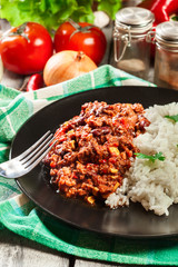 Hot chili con carne with ground beef, beans, tomatoes and corn served with rice
