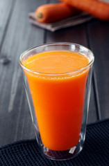 Delicious drink, carrot juice. On wooden table
