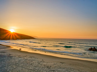 Couple walking on the beach in the sunset