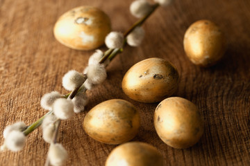 Golden colored eggs, pussy willow. Easter background 