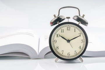 Clock and book with white background.