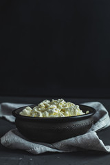 Homemade cottage cheese in a black ceramic bowl