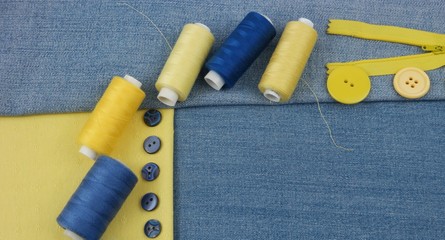 Fashion trends in clothing design, classic blue jeans and yellow cotton. Assortment of the accessories for sewing and needlwork