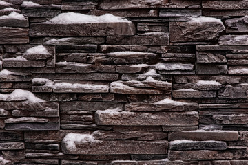 Stone wall covered with snow